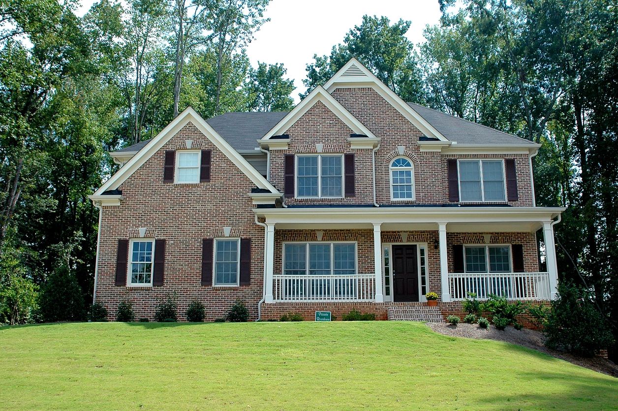 A large brick house with white trim and black shutters.